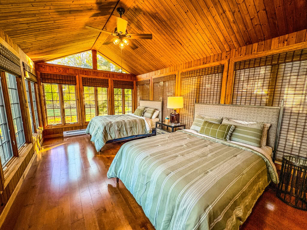 Una cama queen en una habitación compartida de dos camas queen con baño compartido en una casa moderna junto al lago