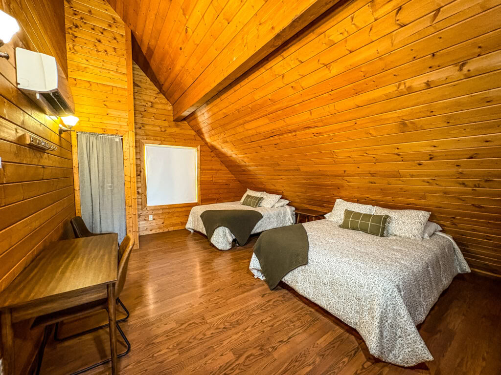 Una cama loft queen en una cabaña loft compartida de dos camas queen con baños compartidos